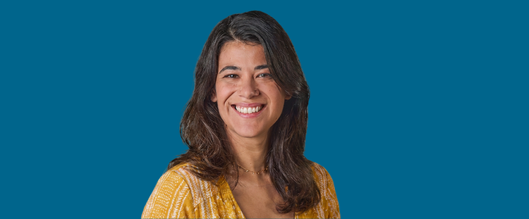 Mujer adulta sonriendo sobre un fondo azul