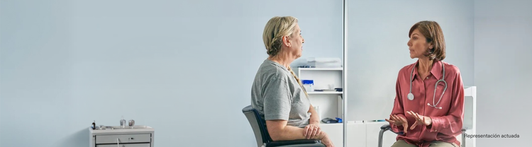Representación actuada de una doctora adulta hablando con una paciente en un consultorio médico